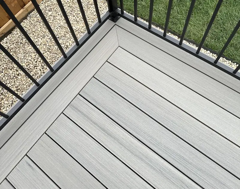 Close-up of grey composite decking with picture-frame border and black aluminum railing, Edmonton — TrueBlue Builders Ltd